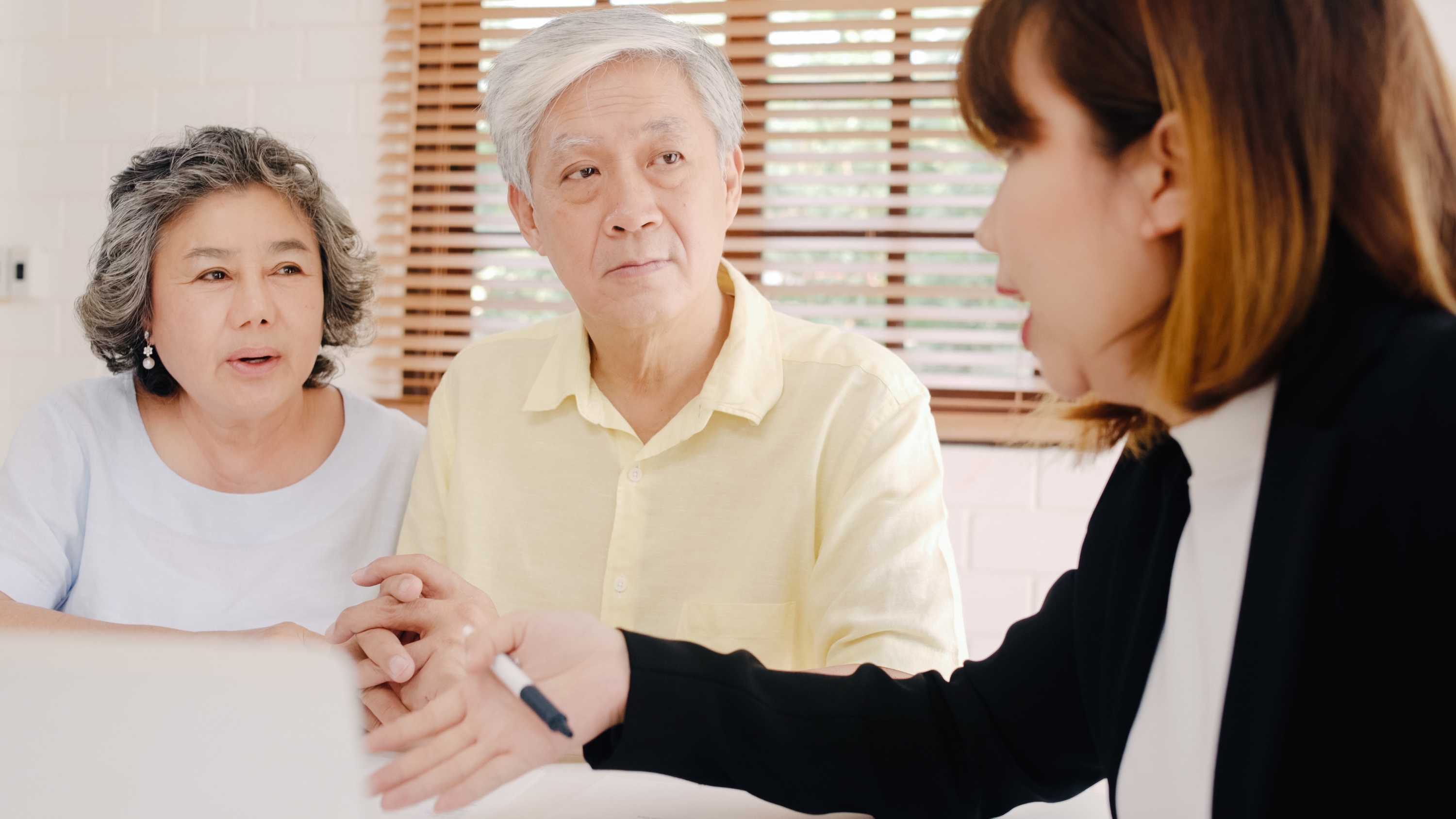 female agent talking to elderly couple about insurance