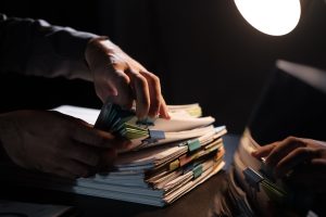 business-employee-hand-working-in-stacks-paper-fil-2025-01-10-11-22-15-utc-min