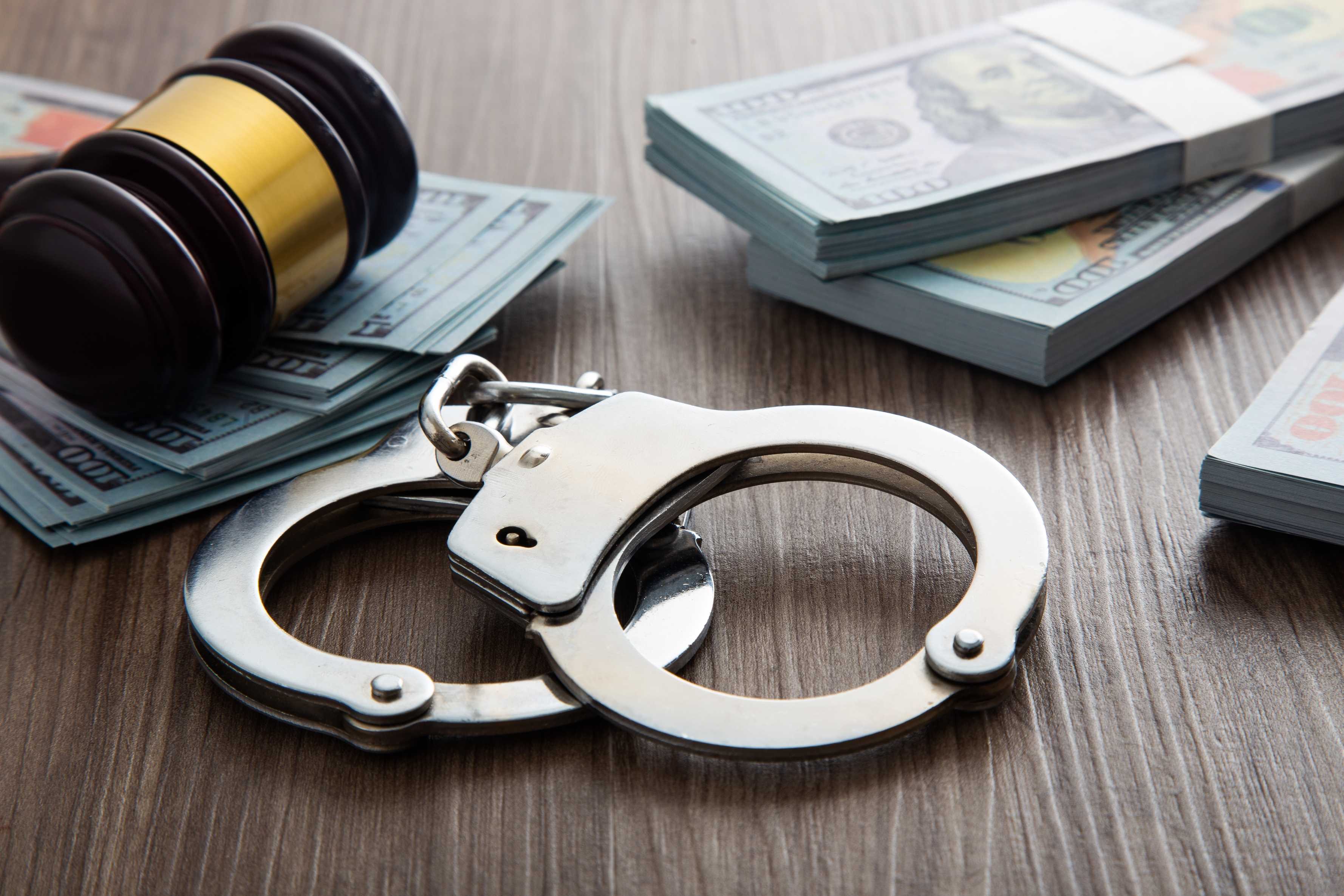 handcuffs and a bundle of dollars on a table