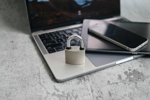laptop with tablet, phone and padlock on top