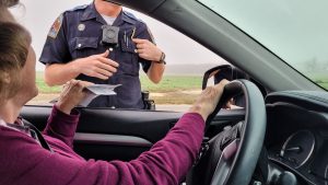 senior woman handing papers to a police