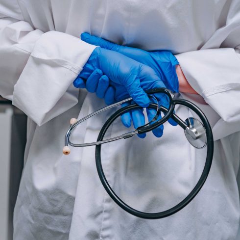 doctor in a white robe holding a phonendoscope