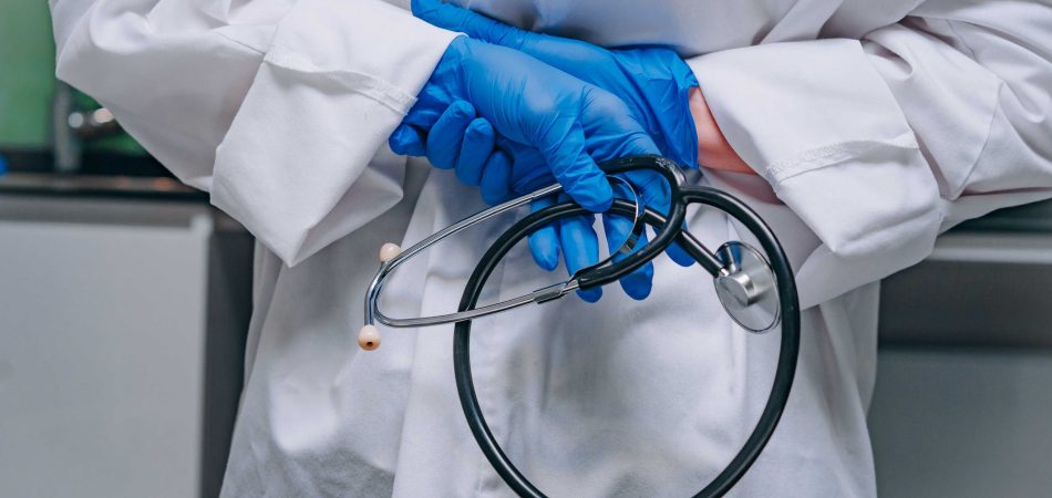 doctor in a white robe holding a phonendoscope