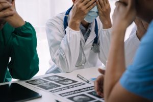 Medical team checking pie chart data of monthly audit report and give a negative, conference team.